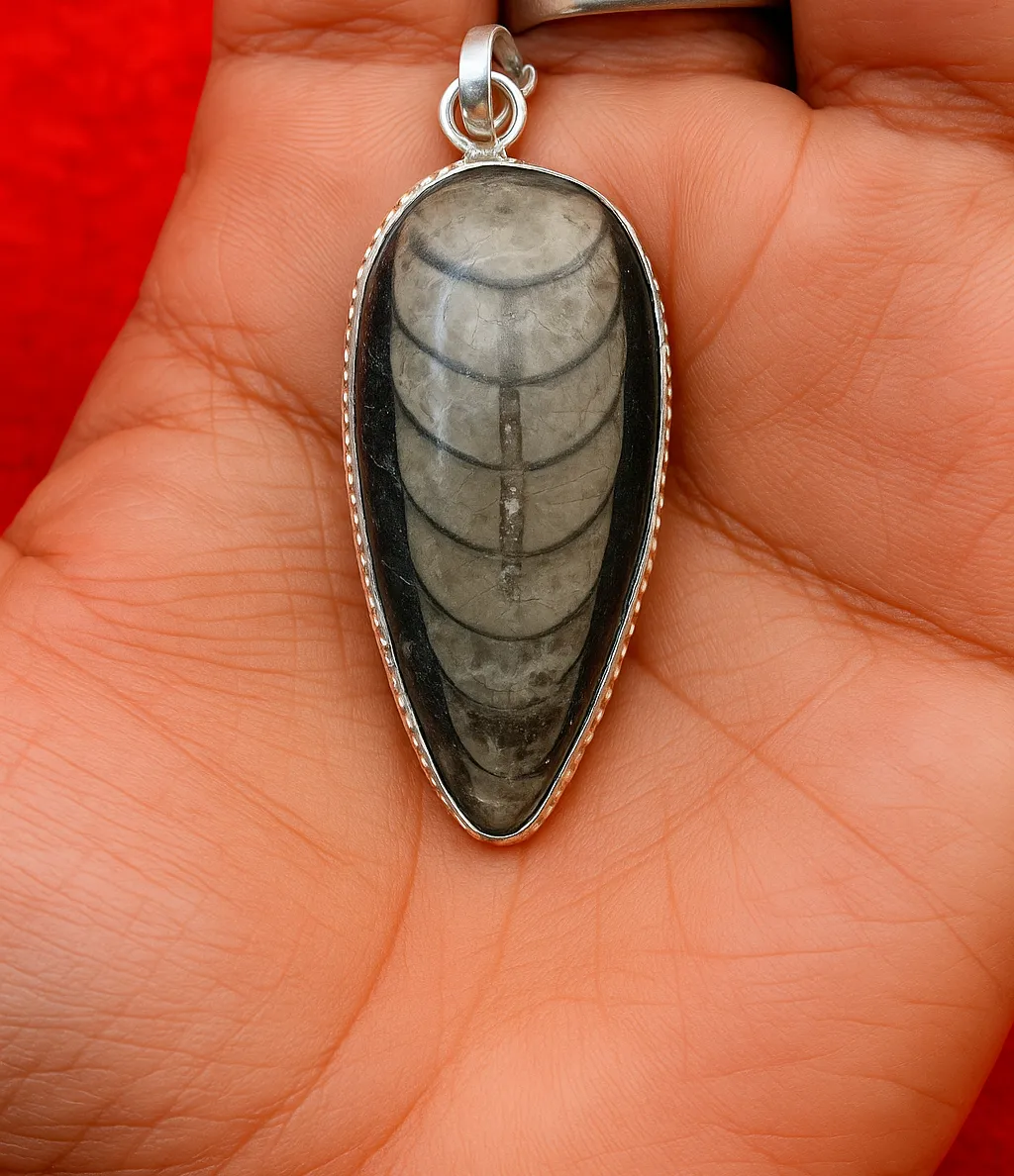 orthoceras kuber stone pendants natural fossil jewelry1 Orthoceras Kuber Pendant in hand, showing real size and silver setting of the fossil crystal pendant